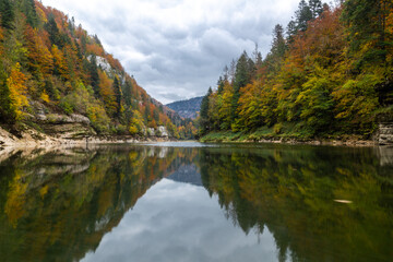 Fototapeta na wymiar Couleurs d'automne sur le Doubs, à Villers-le-lac, en Franche-Comté, à la frontière entre la France et la Suisse