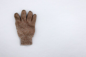winter knitted glove on the white snow
