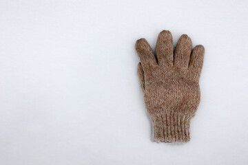 winter knitted glove on the white snow