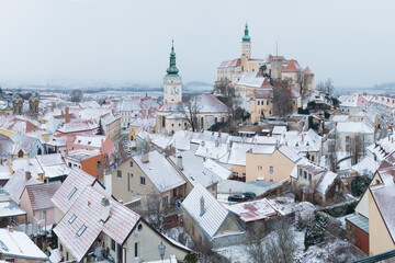 Fototapeta premium Scenic panorama romantic view of beautiful historical landmark Mikulov Castle and historical city centre of Mikulov in South Moravia, Czech Republic. Castle at sunrise near Austria border. Winter time
