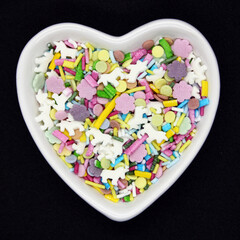 Confectionery multicolored sprinkles on a black background.