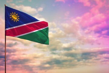 Fluttering Namibia flag mockup with the space for your content on colorful cloudy sky background.