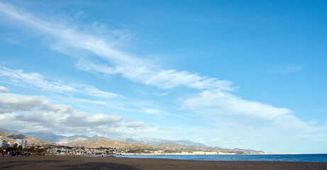 Beautiful shot of the beach of torre del mar in a sunny day with clouds in the sky