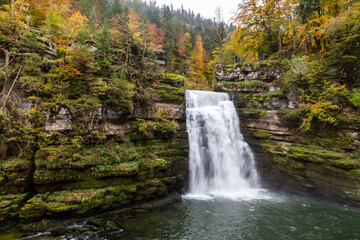 Fototapeta na wymiar Couleurs d'automne au saut du Doubs, une chute de 27 mètres de hauteur sur le Doubs, à Villers-le-lac, en Franche-Comté, à la frontière entre la France et la Suisse