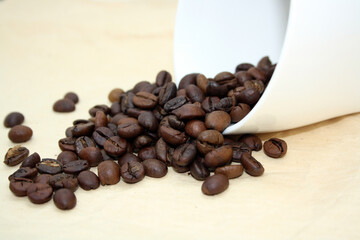 Grains of fragrant fresh coffee on craft paper.