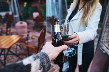 Couple toasting with wine and beer.