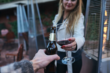 Couple toasting with wine and beer.