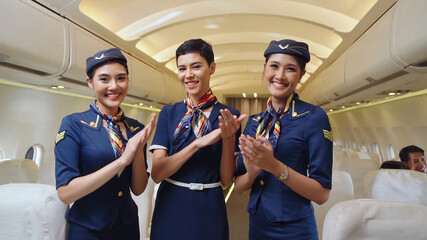 Cabin crew clapping hands in airplane . Airline transportation and tourism concept.
