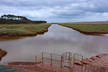 The brown, meandering river Otter as it flows through the flood plain and nature reserve at...