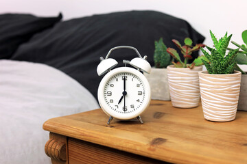 An Alarm Clock Sat On A Bedside Cabinet.