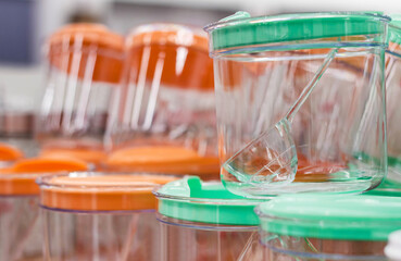 Photo of different colored plastic boxes and containers standing on shelf in store.