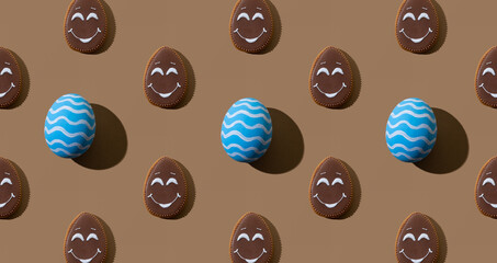 Easter background. Festive pattern. Holiday composition. Blue painted eggs brown chocolate gingerbread biscuit with smiley face symmetrical arrangement isolated on beige.