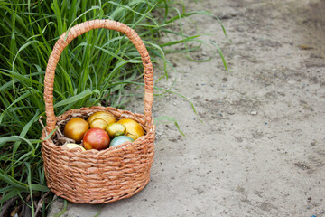 Easter colored eggs in a basket in the grass.Bright family holiday of Easter