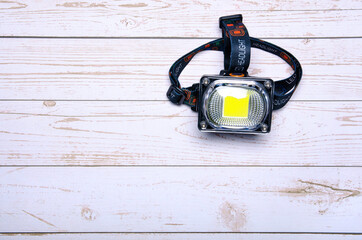 Head torch flashlight led on wooden background