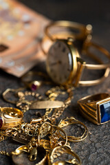 Old and broken jewelry  and on Euro banknotes on dark background. Sell gold for money  concept.