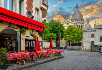 Cozy street with tables of cafe in quarter Montmartre in Paris, France. Architecture and landmarks of Paris. Postcard of Paris - obrazy, fototapety, plakaty