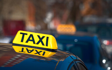 Taxi light sign or cab sign in yellow color on top of the car, blurred background. Taxi car sign on...