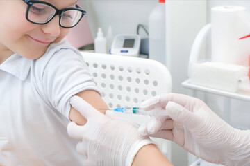 Little boy receiving vaccination at the clinic, close up