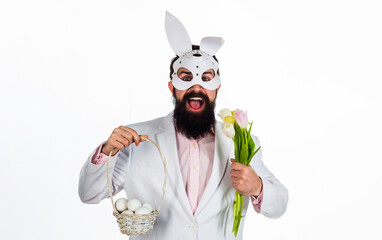 Naklejka premium Man in rabbit mask with Easter basket eggs and flowers.