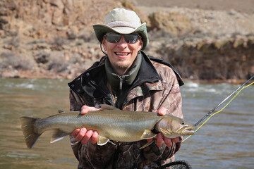 adult fisherman holding steelhead trout