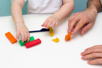 Boy playing with plasticine. Child molding modeling clay. Fine arts for toddler. Art Lesson in daycare.