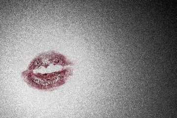 kiss on a transparent background: the print of the girl's lips on the sparkling tinted glass, discoloration, selective focus on central subject