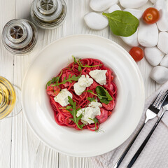 Pasta with herbs and cheese on a white wooden table
