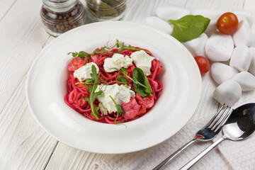 Pasta with herbs and cheese on a white wooden table

