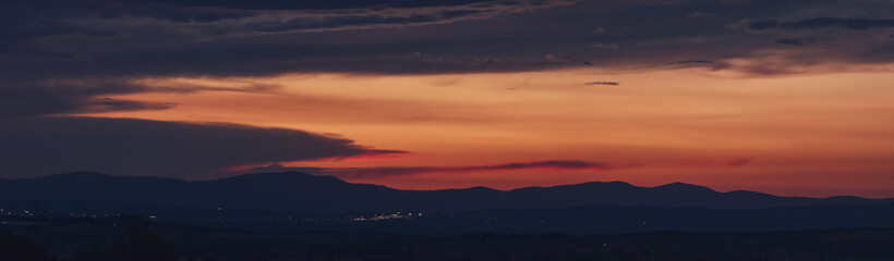 Atardecer en la Sierra de Guadarrama en Madrid, España. Cielo anaranjado con los últimos rayos del sol resaltando la silueta de las montañas ubicadas al norte de Madrid.