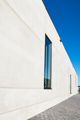 détail d'un mur de façade en béton d'un immeuble moderne avec fenêtre et ciel bleu 