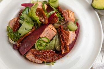 Salmon salad on a white wooden table
