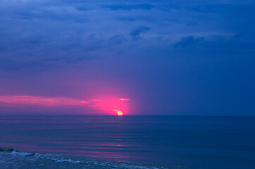 Fototapeta premium Colorful sunrise with sun on cloudy sea
