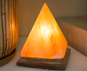 The orange pyramid-shaped salt lamp is made of natural crystal rock salt, which acts as a tonic anti-stress source, health relax.