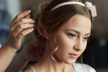 Hairdresser working on bridal knot of hair.