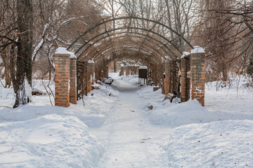 Fototapeta na wymiar Snow-covered deserted hiking trail in a city park in cold winter