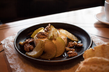 Dessert of camembert cheese and pears in syrup with honey in caffee