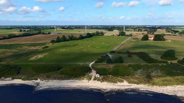 Flying into the sunset at the baltic coast in Marielyst, Denmark. Wind turbines on the horizon and gulls flying over the sea. Relaxing holiday mood.
