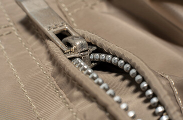 The lock with a zipper is close-up on the clothes of gray color. Zipper with lock.