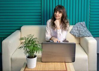 Young female blogger works with a laptop online. The concept of remote learning.