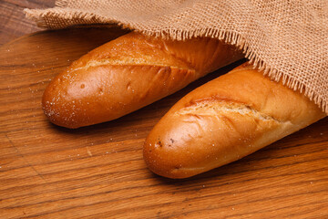 Fresh baguette bread on wooden background