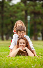 Fototapeta na wymiar happy mother with children in the park outdoors