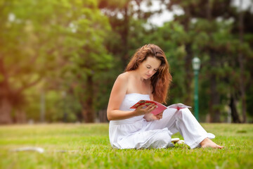 Fototapeta na wymiar young woman reading a book in the park outdoors