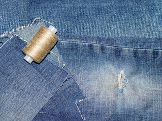 Old jeans with a hole ready to upcycling and thread. Concept of things reuse and natural resources...