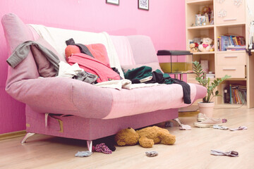 Room of a teenage girl with scattered clothes and things. The concept of a mess, general cleaning.