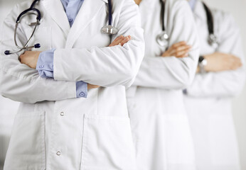 Group of modern doctors standing as a team with arms crossed in hospital office and ready to help patients. Medical help, insurance in health care, best disease treatment and medicine concept