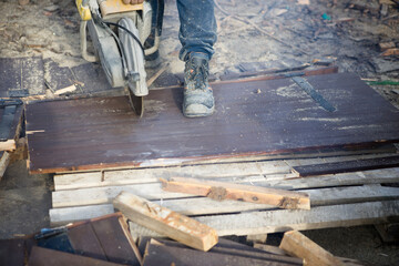 A worker cuts the wood with a petrol saw
