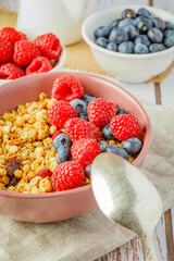 muesli with blueberries and raspberries on wooden table