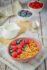 muesli with blueberries and raspberries on wooden table