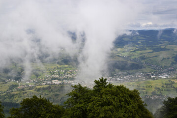 Fototapeta premium Clouds over village in the valley. Wide angle horizon view, Carpathian mountains, Ukraine