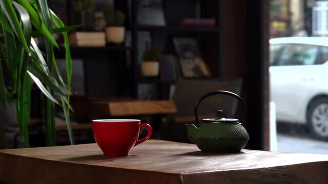 Cinematic Slow Motion Pouring Herbal Tea in Red Cup from Green Tea Pot